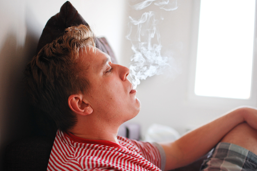 man blowing out secondhand meth smoke