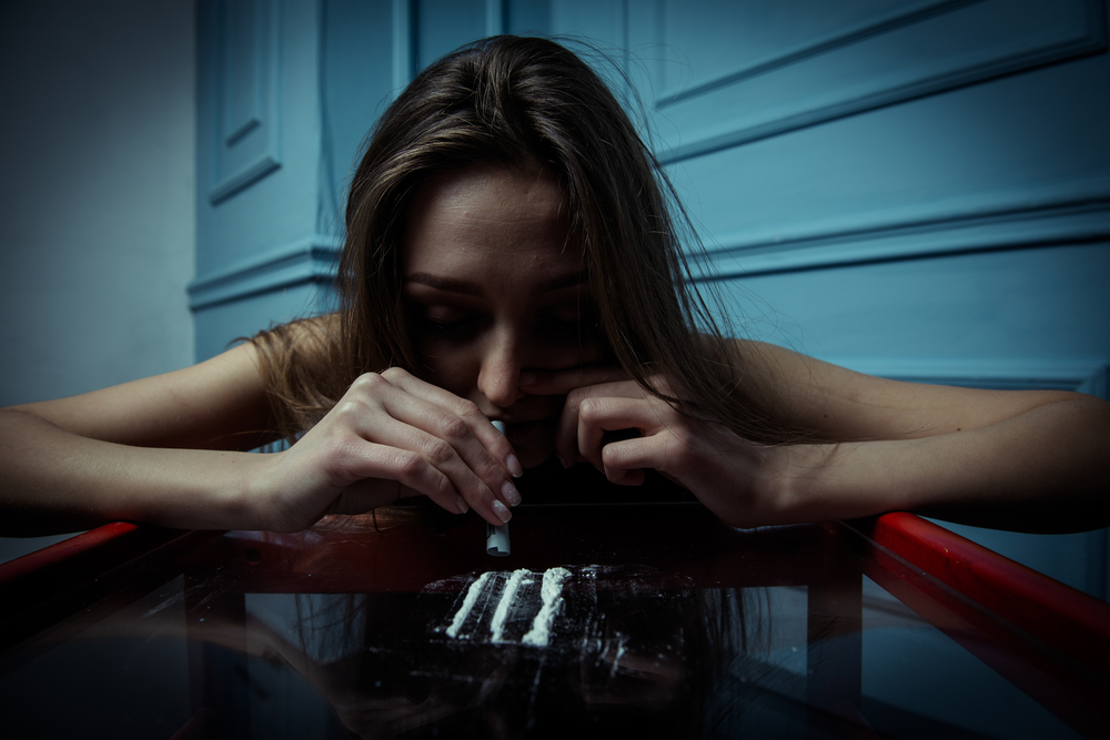 woman snorting cocaine on table